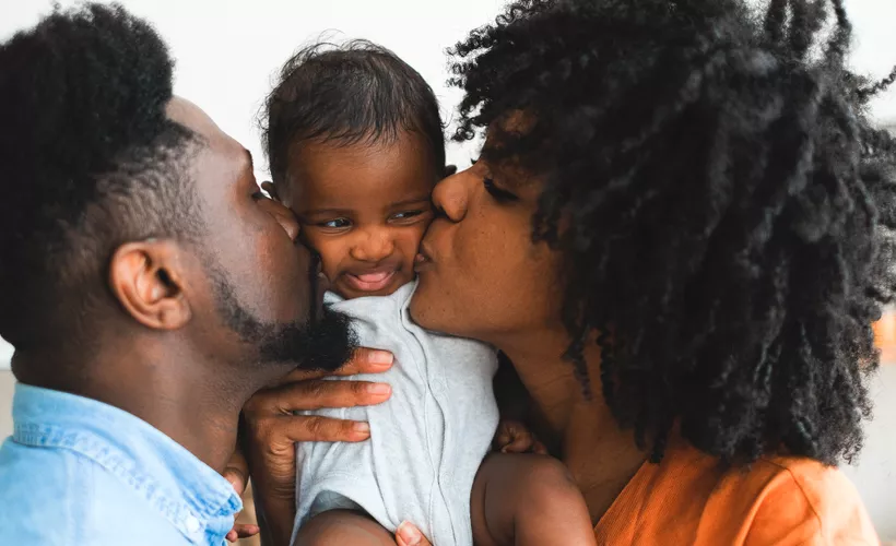 Young couple kissing their baby